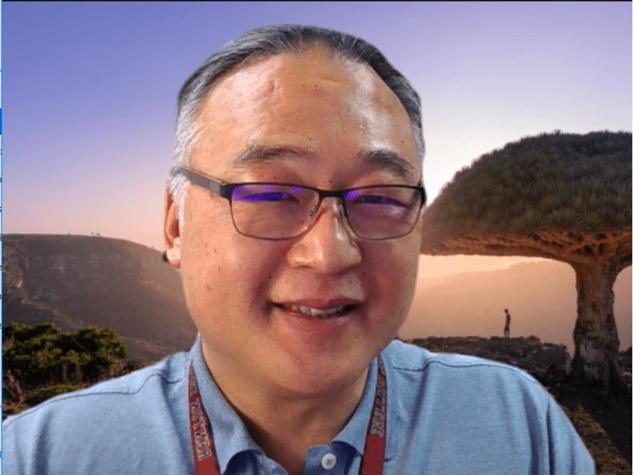 Headshot of Yun Moh smiling. Yun has dark hair and is wearing glasses.