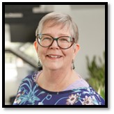 Headshot of Dr. Jenni Hayman smiling. Jenni wears glasses and has light eyes, very short grey hair, and a fair complexion.